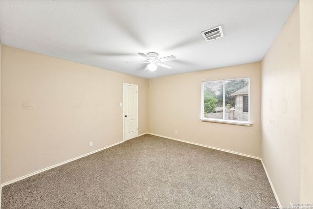carpeted empty room with baseboards, visible vents, and ceiling fan