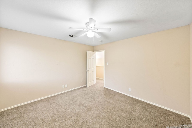 carpeted spare room featuring a ceiling fan, baseboards, and visible vents