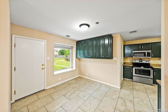kitchen with stainless steel appliances, green cabinetry, visible vents, and decorative backsplash