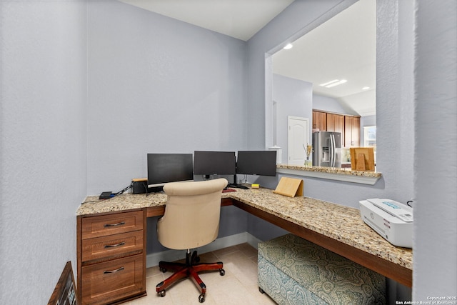 home office with baseboards, lofted ceiling, light tile patterned floors, and built in study area
