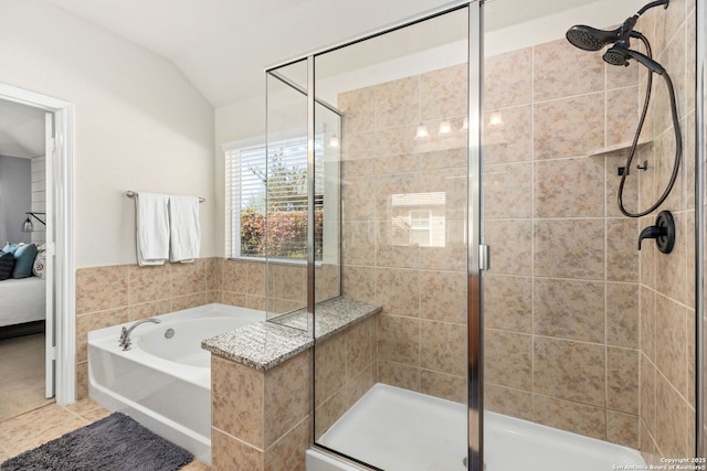 ensuite bathroom with a garden tub, a shower stall, tile patterned floors, connected bathroom, and lofted ceiling