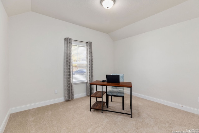 office space featuring baseboards, carpet, and vaulted ceiling