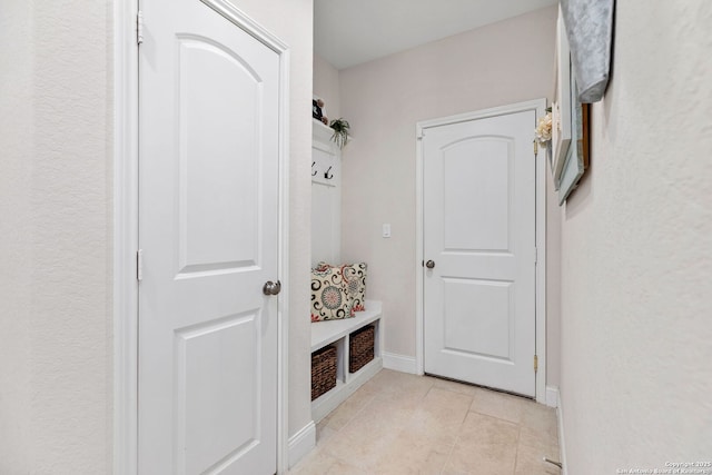 mudroom featuring baseboards and light tile patterned floors