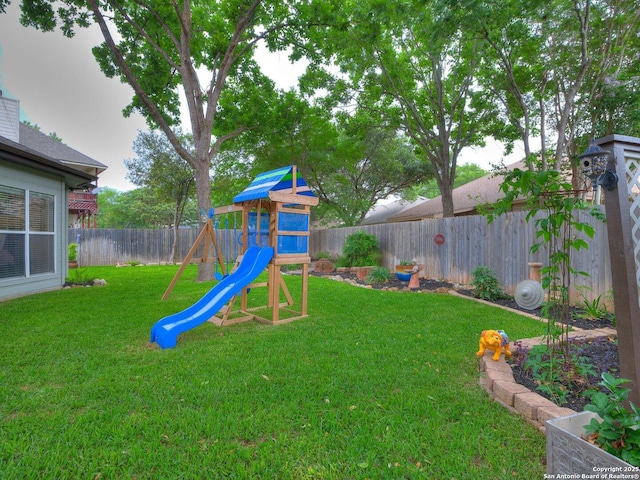 view of play area with a lawn and a fenced backyard