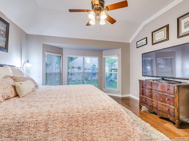 bedroom featuring a ceiling fan, crown molding, wood finished floors, baseboards, and lofted ceiling