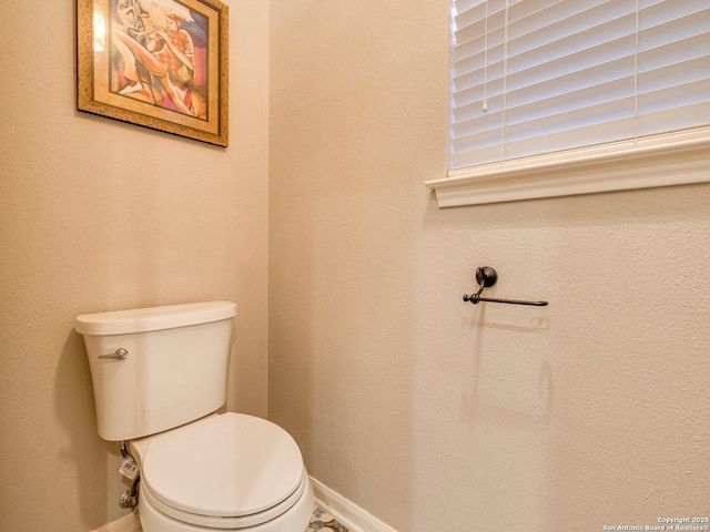 bathroom featuring baseboards and toilet