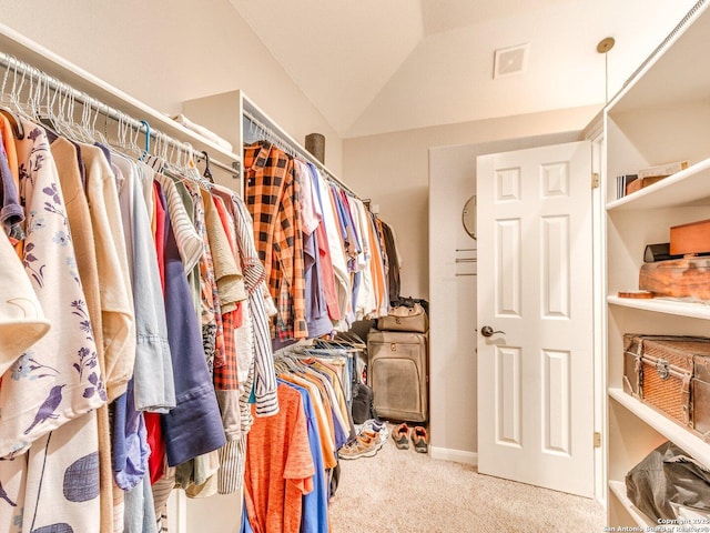 spacious closet with carpet, lofted ceiling, and visible vents