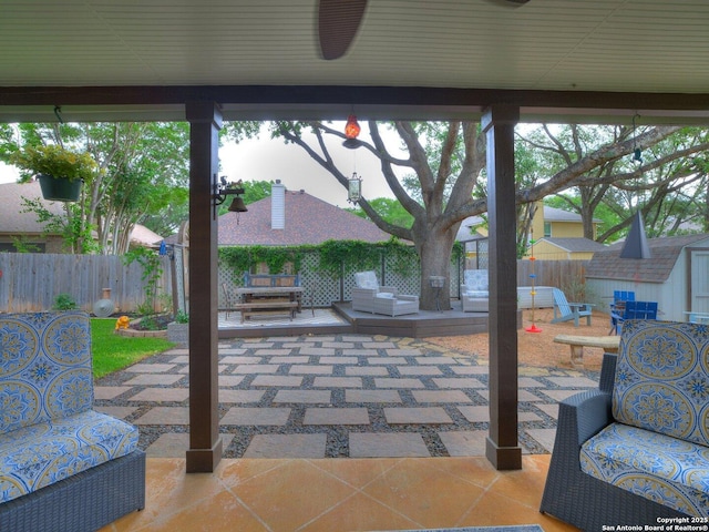 view of patio featuring a fenced backyard, an outdoor structure, outdoor lounge area, and a storage shed