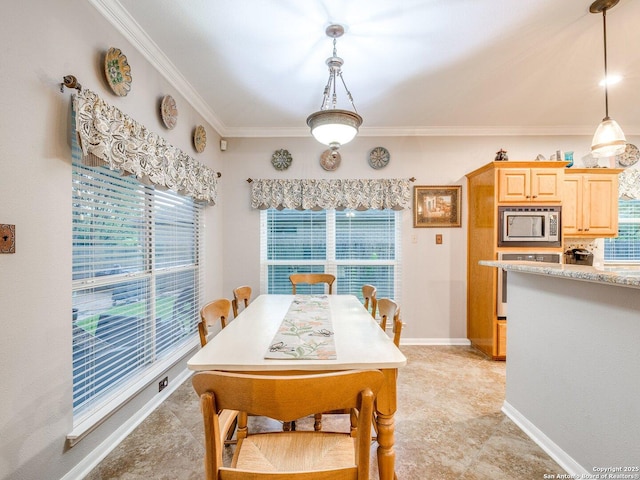 dining area featuring crown molding, baseboards, and a healthy amount of sunlight