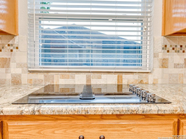 interior details featuring light countertops and tasteful backsplash
