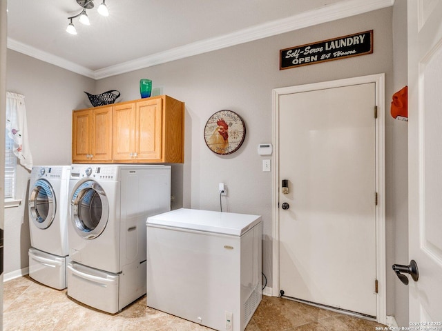washroom featuring cabinet space, crown molding, and washing machine and dryer