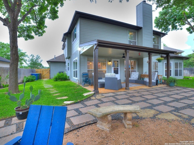 rear view of house with a ceiling fan, a chimney, fence, an outdoor hangout area, and a patio