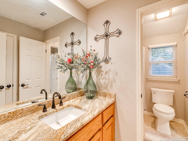 bathroom with visible vents, vanity, toilet, baseboards, and tile patterned floors