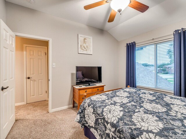 bedroom with baseboards, vaulted ceiling, light carpet, and ceiling fan