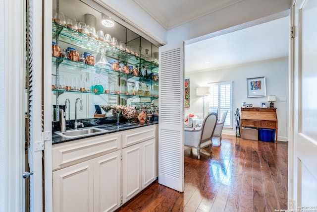 7731 Broadway Unit I-42, San Antonio, TX 78209 - bar featuring indoor wet bar, dark wood-style flooring, ornamental molding, and a sink