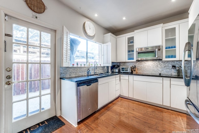 7731 Broadway Unit I-42, San Antonio, TX 78209 - kitchen featuring a sink, appliances with stainless steel finishes, dark countertops, and a healthy amount of sunlight