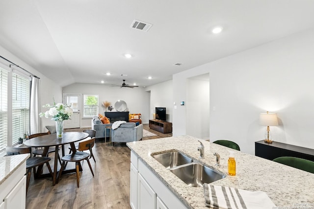 kitchen with ceiling fan, visible vents, a sink, light wood-style floors, and white cabinetry