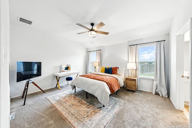 bedroom featuring carpet flooring, visible vents, and multiple windows