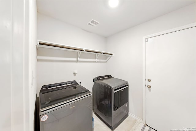 laundry area featuring washer and dryer, laundry area, visible vents, and light tile patterned floors