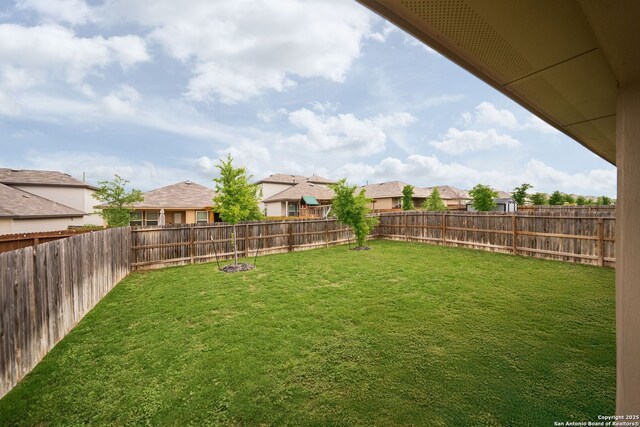view of yard featuring a fenced backyard and a residential view