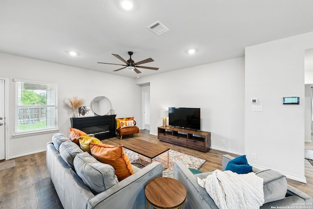 living room featuring recessed lighting, a ceiling fan, visible vents, and wood finished floors
