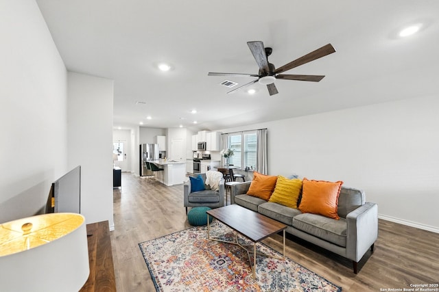 living room with a ceiling fan, visible vents, a healthy amount of sunlight, and light wood-style flooring