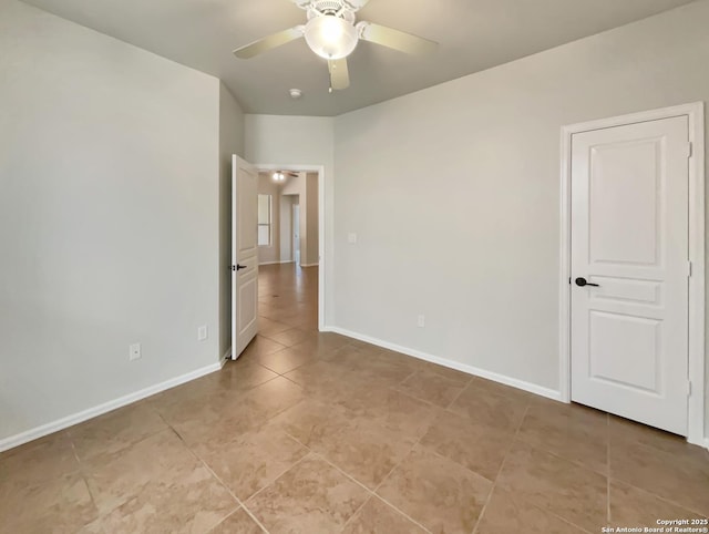unfurnished room with baseboards, ceiling fan, and light tile patterned flooring
