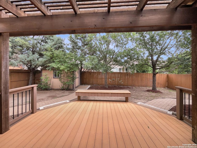 deck with a pergola, an outbuilding, and a fenced backyard