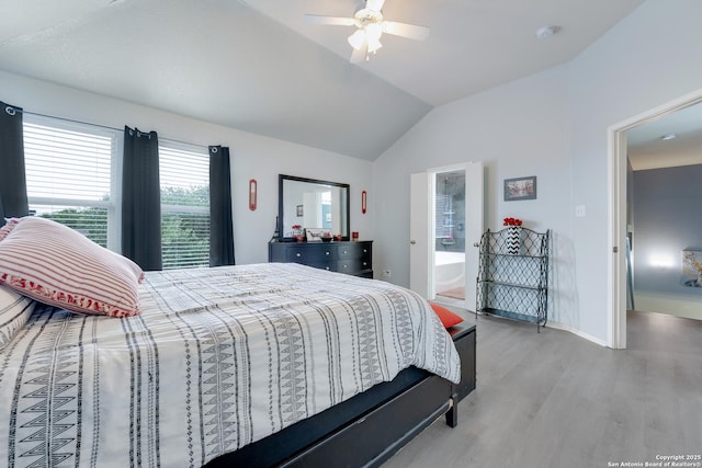 bedroom with ceiling fan, baseboards, lofted ceiling, light wood-style floors, and ensuite bathroom