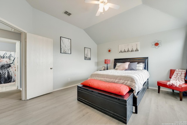 bedroom featuring baseboards, visible vents, wood finished floors, and lofted ceiling