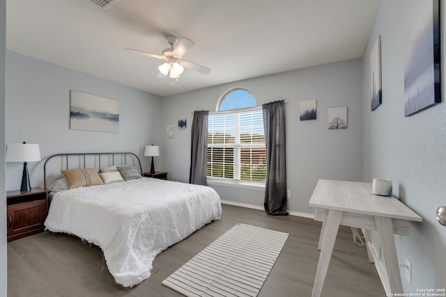 bedroom with baseboards, a ceiling fan, and wood finished floors