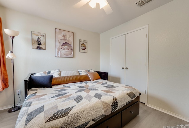 bedroom featuring a closet, visible vents, baseboards, ceiling fan, and light wood finished floors
