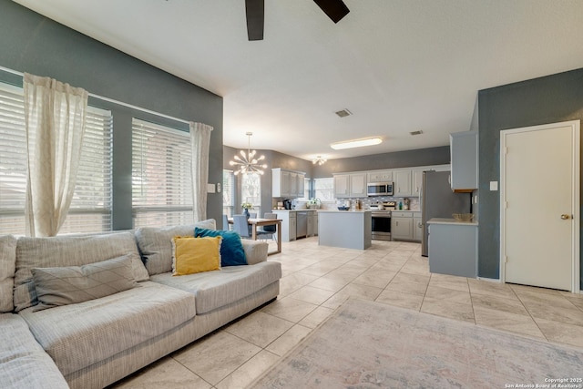 living room with ceiling fan with notable chandelier