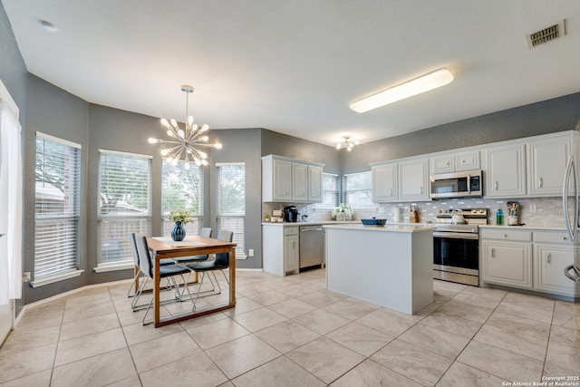 kitchen featuring appliances with stainless steel finishes, an inviting chandelier, visible vents, and tasteful backsplash