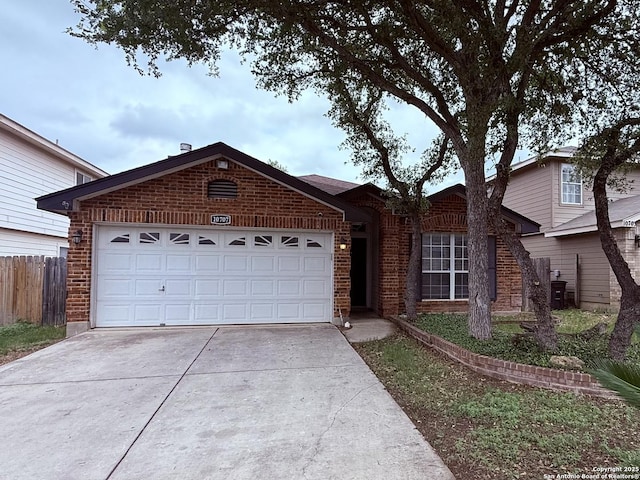 single story home featuring brick siding, an attached garage, driveway, and fence