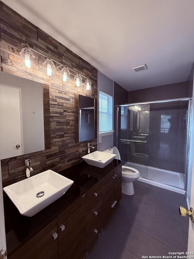 full bathroom with a sink, tasteful backsplash, toilet, and a shower stall
