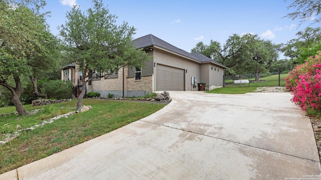view of home's exterior featuring a yard, fence, driveway, and a garage
