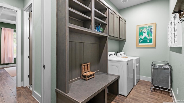 laundry room featuring visible vents, cabinet space, baseboards, washer and dryer, and dark wood-type flooring