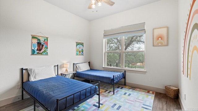 bedroom featuring baseboards, a ceiling fan, and wood finished floors