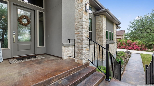 entrance to property with stucco siding and stone siding