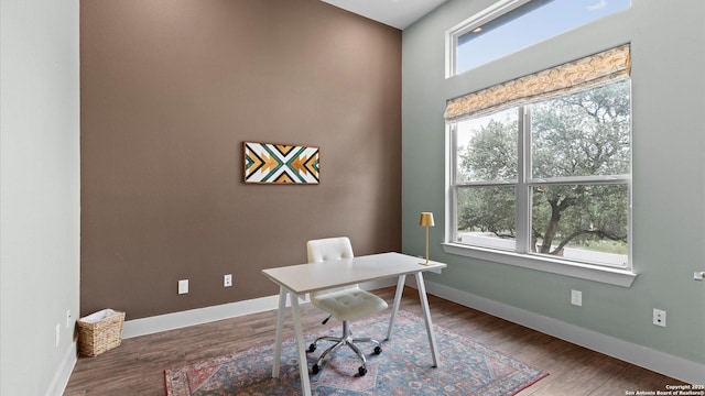 office area with baseboards, plenty of natural light, and wood finished floors
