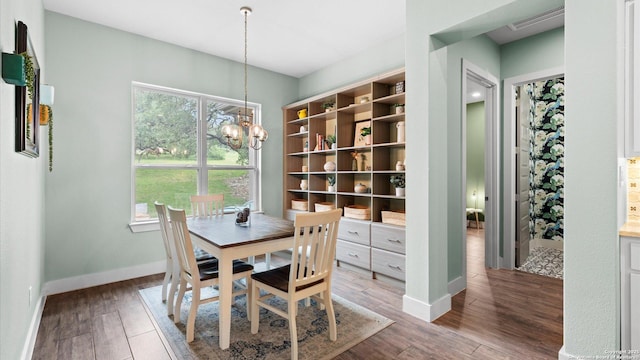 dining area featuring baseboards, a chandelier, a wealth of natural light, and wood finished floors