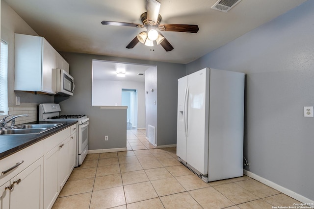 kitchen with ceiling fan, dark countertops, a sink, white appliances, and visible vents