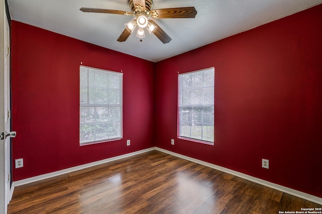 empty room featuring baseboards, a ceiling fan, wood finished floors, and a healthy amount of sunlight