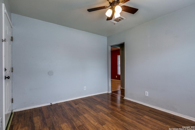 spare room featuring a ceiling fan, baseboards, visible vents, and wood finished floors