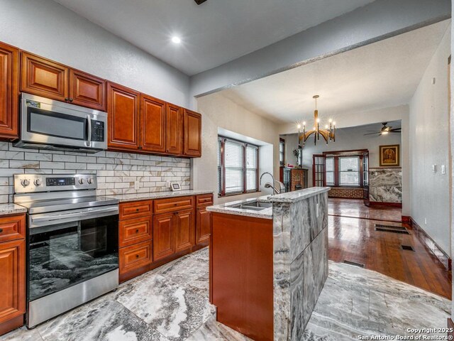 1520 Virginia, San Antonio, TX 78203 - kitchen featuring light stone countertops, appliances with stainless steel finishes, a sink, open floor plan, and tasteful backsplash