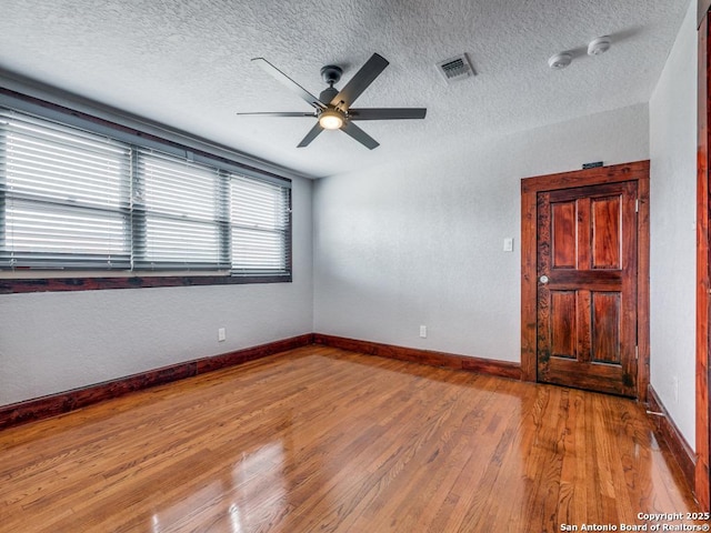 1520 Virginia, San Antonio, TX 78203 - empty room featuring visible vents, wood finished floors, baseboards, ceiling fan, and a textured ceiling