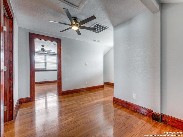 1520 Virginia, San Antonio, TX 78203 - spare room with a textured ceiling, a ceiling fan, baseboards, wood finished floors, and visible vents