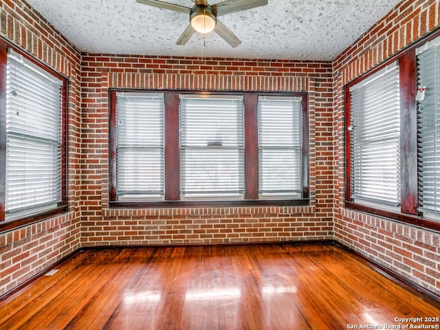1520 Virginia, San Antonio, TX 78203 - unfurnished room featuring a ceiling fan, brick wall, a wealth of natural light, and dark wood-type flooring