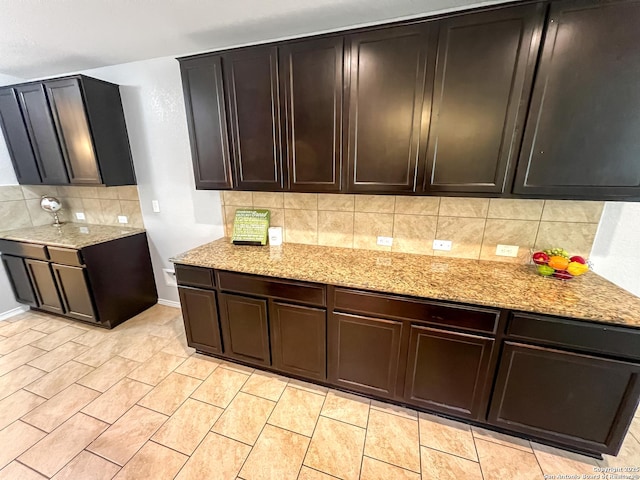 kitchen with light stone counters, baseboards, and tasteful backsplash
